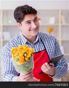 The flower shop assistant offering a bunch of flowers. Flower shop assistant offering a bunch of flowers