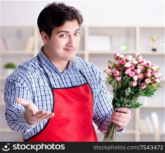 The flower shop assistant offering a bunch of flowers. Flower shop assistant offering a bunch of flowers
