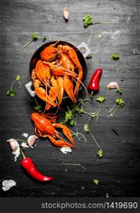 The food delicacies. Boiled crawfish with herbs and spicy peppers. On a black chalkboard.. The food delicacies. Boiled crawfish with herbs and spicy peppers.