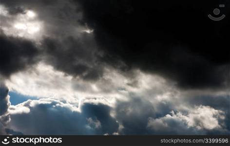 The formation of dark thunder storm clouds with a patch of sun light shining through