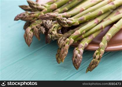 the fresh asparagus on the blue wooden background. veganism and raw foods