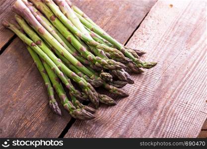 the fresh asparagus on the wooden background. veganism and raw foods