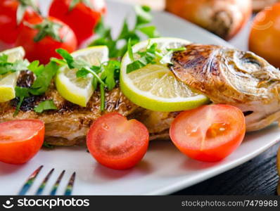 The fried fish served on the plate. Fried fish served on the plate