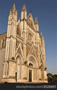 The front facade of the Orvieto Cathedral is ornate and detailed with colorful mosaics, intricate carvings, bronze statues, bell towers and more. It is a magnificent example of 14th century Italian architecture that evolved from Romanesque to Gothic.