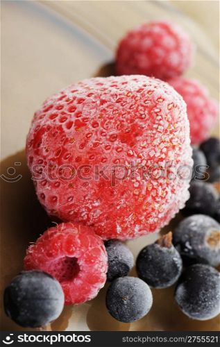 The frozen raspberry, strawberry, bilberry. Berries covered with hoarfrost.