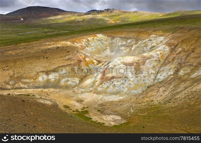 The fumaholes and mud pools in the Krafla volcanic system, with rhyolite mountains, silica and sulfur depositions, creating a spectacular colorful view