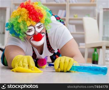 The funny clown doing cleaning at home. Funny clown doing cleaning at home