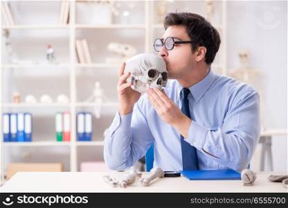 The funny crazy professor studying human skeleton. Funny crazy professor studying human skeleton