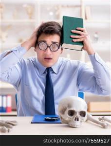 The funny crazy professor studying human skeleton. Funny crazy professor studying human skeleton