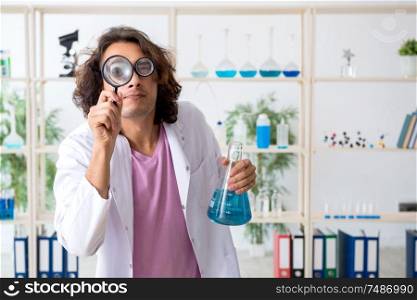 The funny male chemist working in the lab. Funny male chemist working in the lab