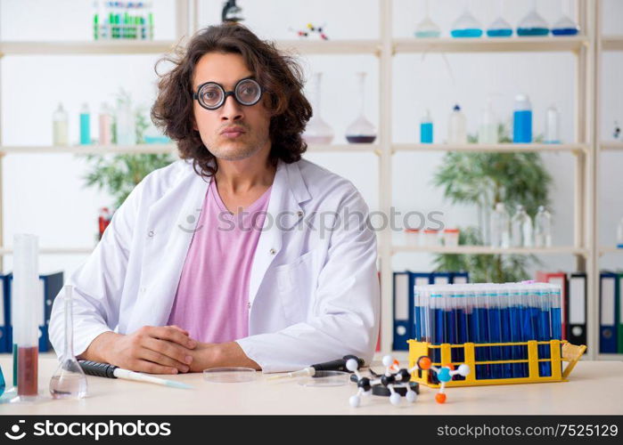 The funny male chemist working in the lab. Funny male chemist working in the lab