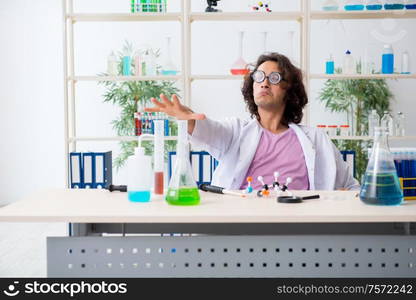 The funny male chemist working in the lab. Funny male chemist working in the lab