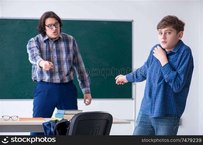 The funny male teacher and boy in the classroom . Funny male teacher and boy in the classroom