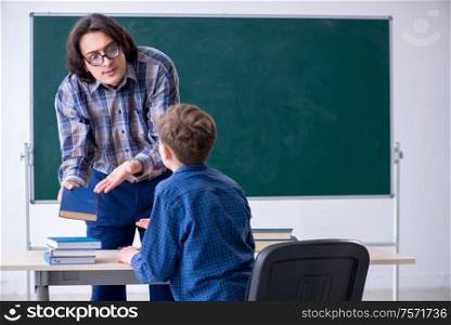 The funny male teacher and boy in the classroom. Funny male teacher and boy in the classroom