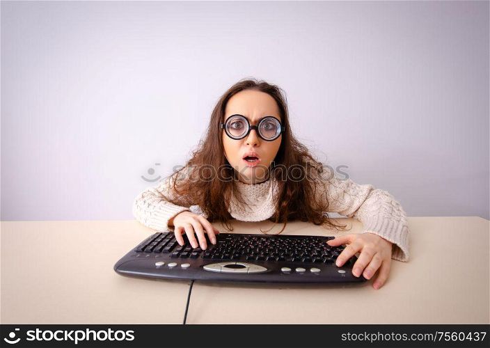 The funny nerd girl working on computer. Funny nerd girl working on computer