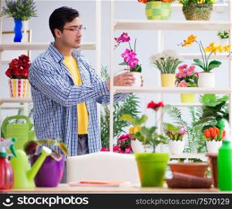The gardener florist working in a flower shop with house plants. Gardener florist working in a flower shop with house plants