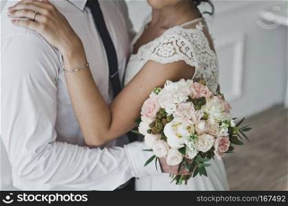 The gentle embrace of a man and a woman.. Man hugs a womans waist holding a bouquet of flowers 7396.