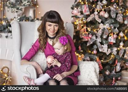 The gentle embrace of mother and daughter on the Christmas decorations.. Mom is hugging daughter in the background of the Christmas tree 9615.