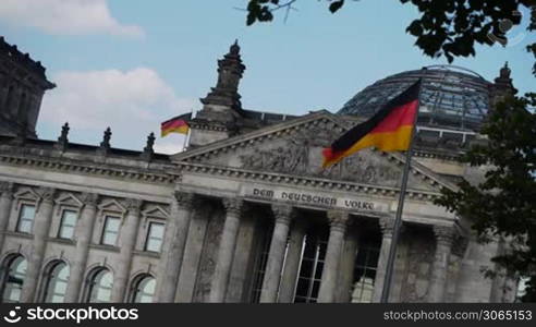 the german parliament building reichstag with waving flags, das deutsche Parlament, der Reichstag in Berlin, mit wehenden Fahnen
