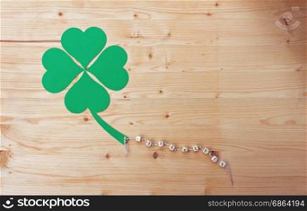 The german words for Good Luck and a cloverleaf on a cord on wood