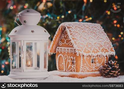 The gingerbread house over defocused lights of Chrismtas tree. The gingerbread house