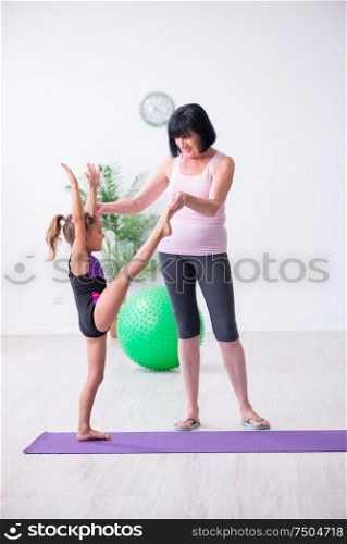The girl and mother exercising at home. Girl and mother exercising at home