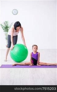 The girl and mother exercising at home. Girl and mother exercising at home