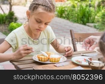The girl carefully coated with confectionery glaze Easter cupcakes