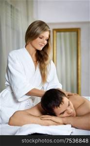 The girl does massage to the patient in spa salon
