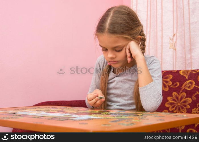 The girl does not know where to put the next puzzle element