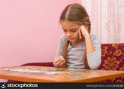 The girl does not know where to put the next puzzle element
