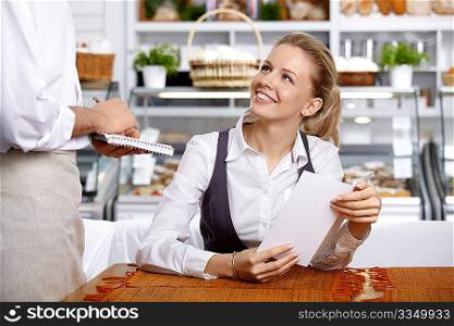 The girl does the order to the waiter in cafe