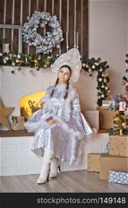 The girl dressed as the snow Maiden granddaughter of Santa Claus.. Portrait of a snow Maiden at the new years decorated Christmas tree 991