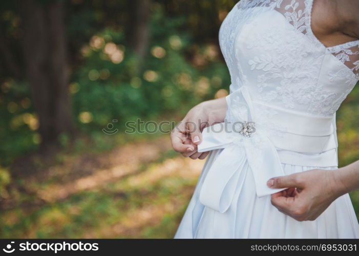 The girl dresses a wedding dress.. Clothing of a wedding dress 1674.