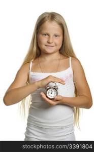 The girl holds an alarm clock in hands. It is isolated on a white background
