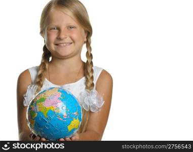 The girl holds the globe collected from puzzle in hands. Selective focus. It is isolated on a white background
