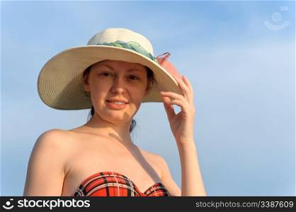 The girl in a hat against the blue sky
