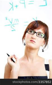 The girl in glasses thoughtfully looks at formulas