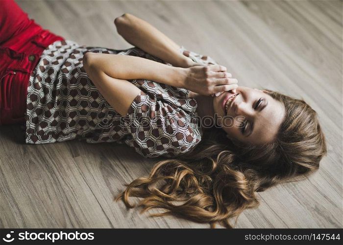 The girl in his dreams lying on the parquet floor with podniecenie to his lips with his hands.. The girl in a fit of tenderness lying on the floor 6972.