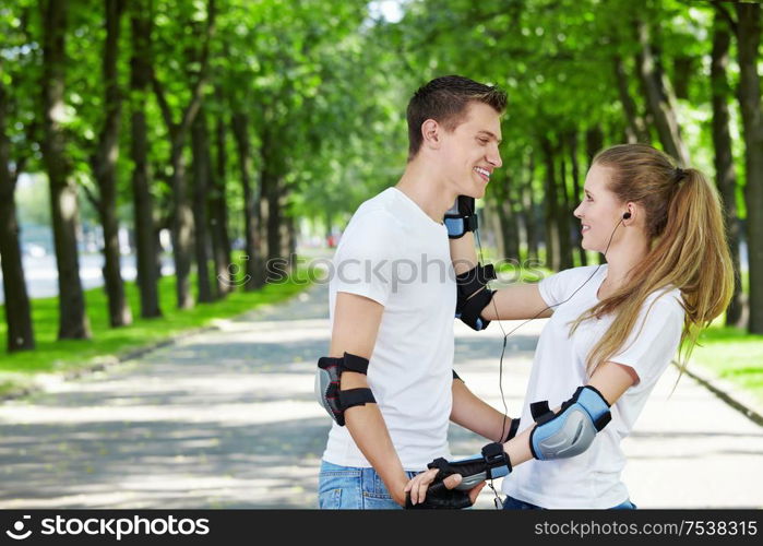 The girl in park gives an ear-phone to the man