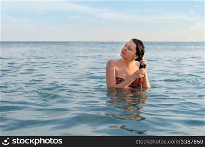 The girl in water. The nice young girl in blue the sea