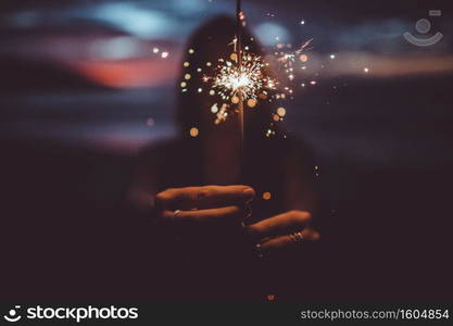 the girl is holding a sparkler on the beach