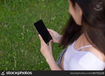 The girl is holding a white phone in her hands, a sports watch on her hand.. The girl is holding a white phone in her hands