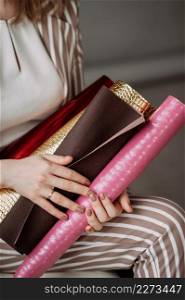The girl is holding scrolls with various materials for book covers.. Scrolls with cover materials in the hands of a business woman 4135.