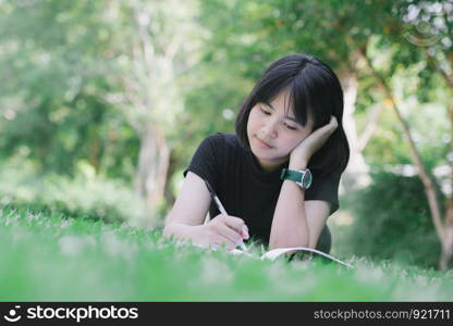 The girl is sitting in the lawn in the garden.