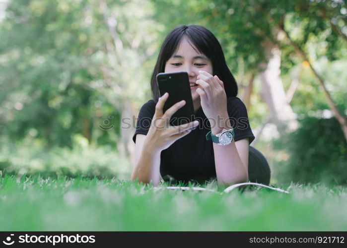 The girl is sitting in the lawn in the garden.