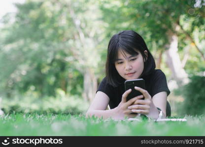 The girl is sitting in the lawn in the garden.