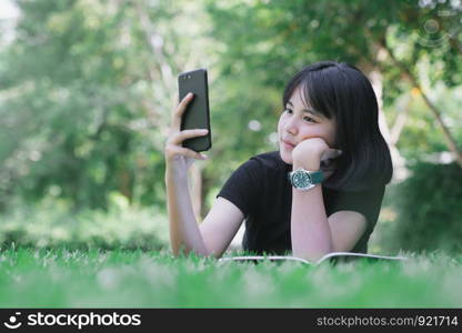 The girl is sitting on the lawn in the garden