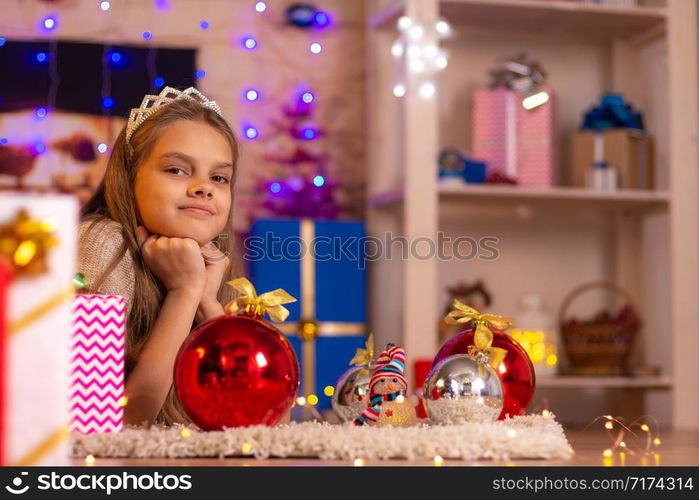 The girl lies on the mat in the New Year&rsquo;s interior and looked into the frame