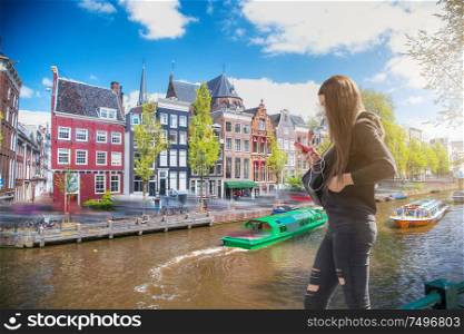 The girl listens to music and walks around Amsterdam